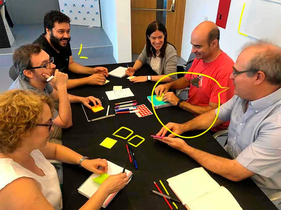 Javier trabajando con personal público en el diseño de servicios con post-its, rotuladores, folios...