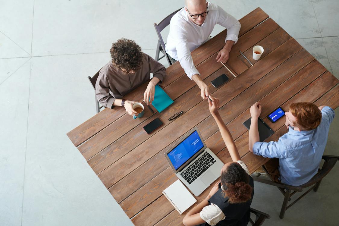 Personas alrededor de una mesa, trabajando juntas