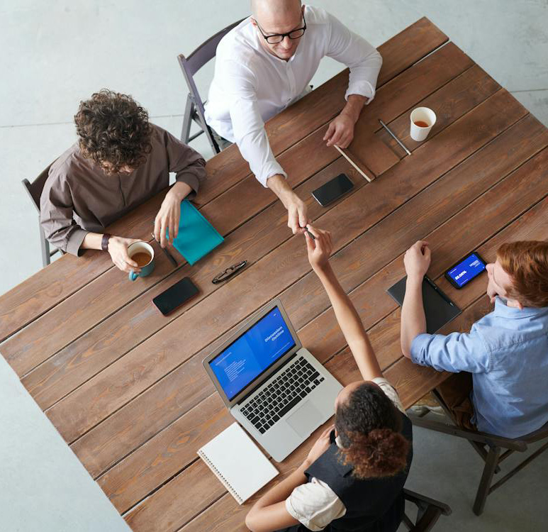 Personas alrededor de una mesa, trabajando juntas