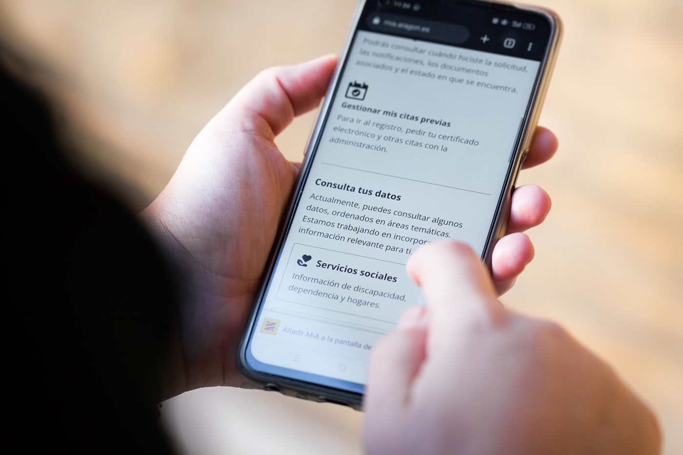 Una persona sostiene un teléfono móvil y puede verse que está dentro de MiA