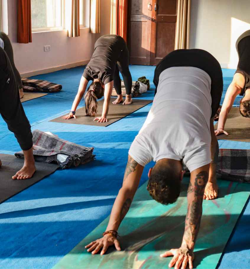 Personas haciendo yoga en la sala de un gimnasio