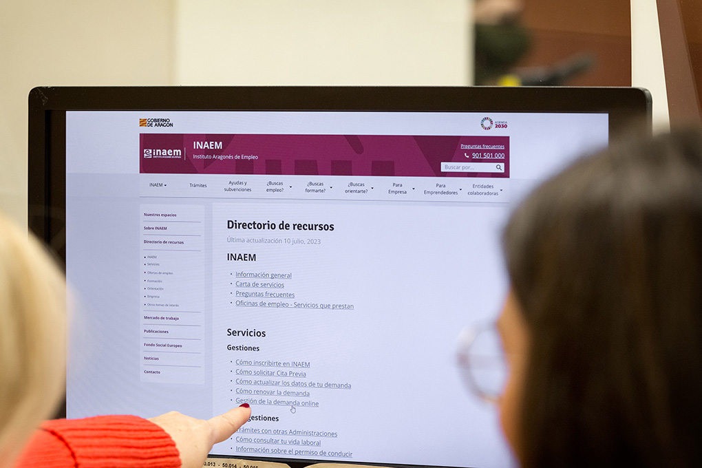 Dos personas miran una pantalla de ordenador y señalan con el dedo