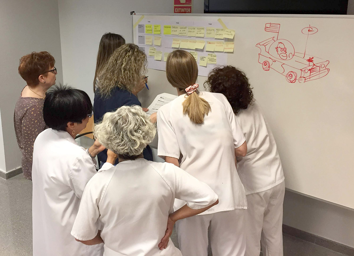 Compañeras del hospital trabajando en equipo ante una pizarra