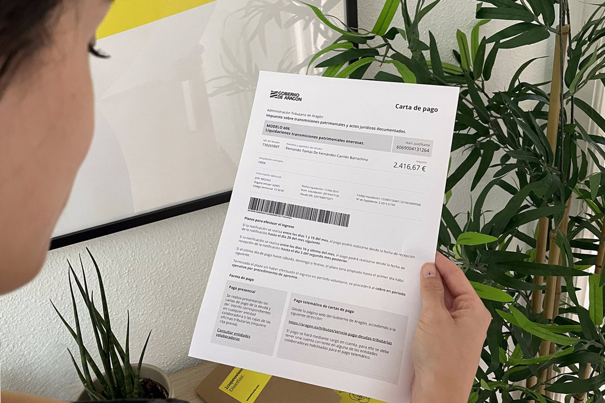 Una mujer sostiene en su mano una carta de pago del Gobierno de Aragón