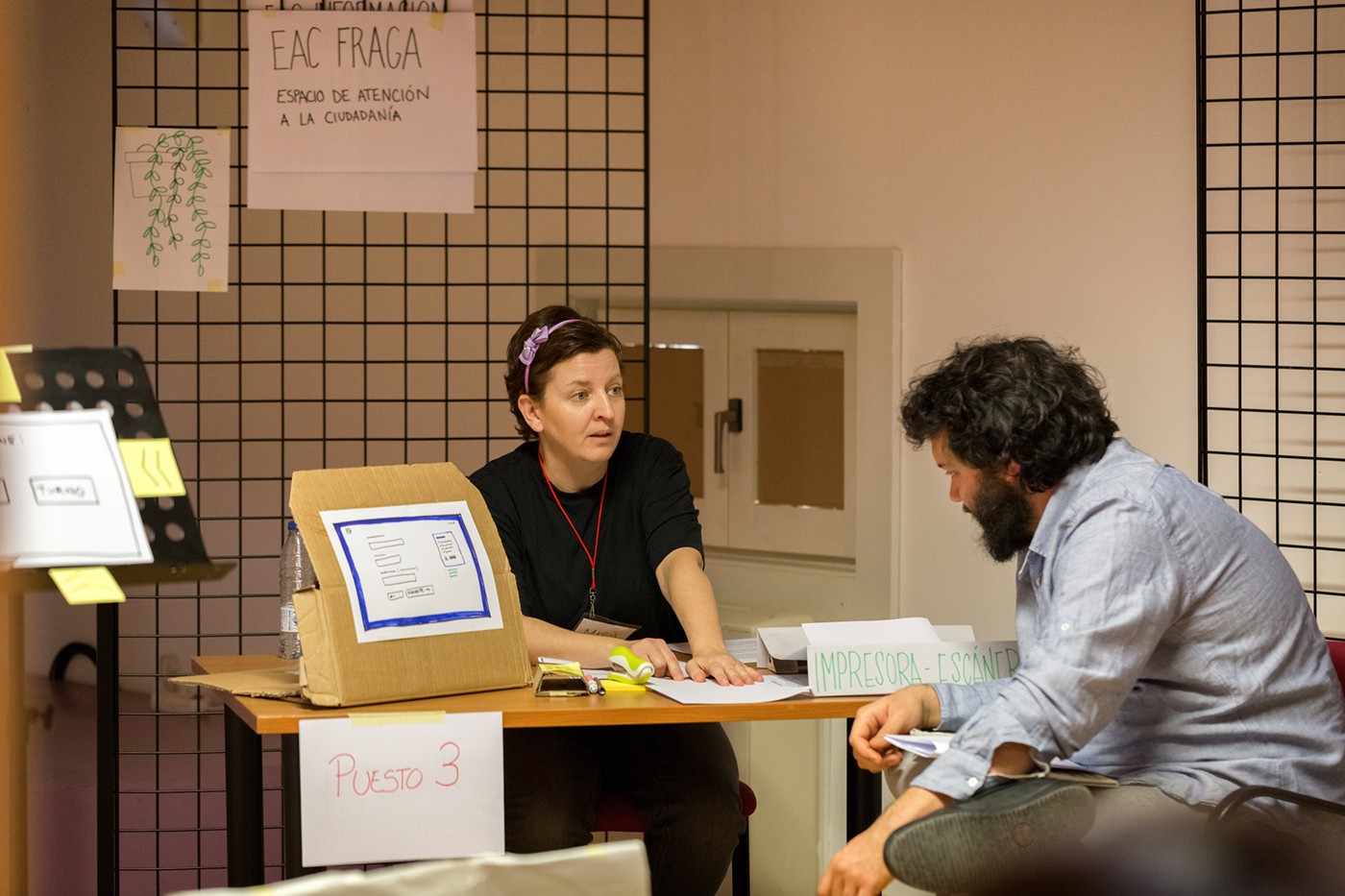 Dos personas escenifican un momento de atención presencial en una oficina