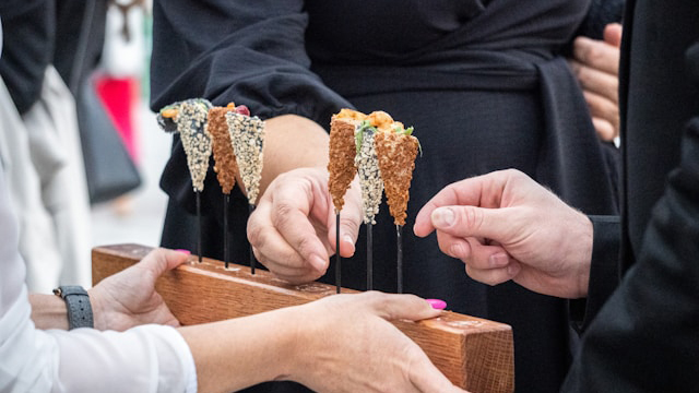 Una camarera ofrece un entrante a los invitados de una boda.